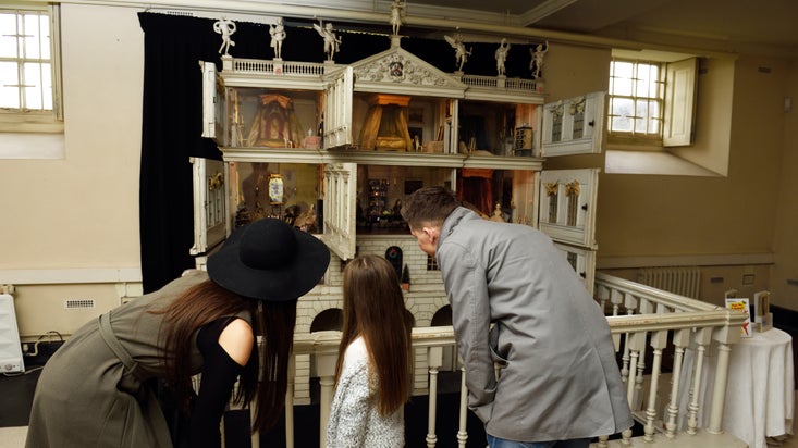 A family look at the doll's house at Uppark, West Sussex
